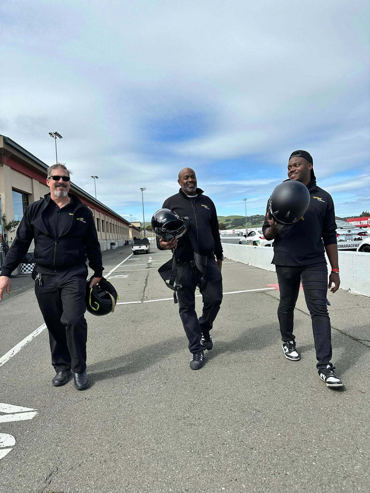 LightSpeed instructors walking pit lane with their helmets